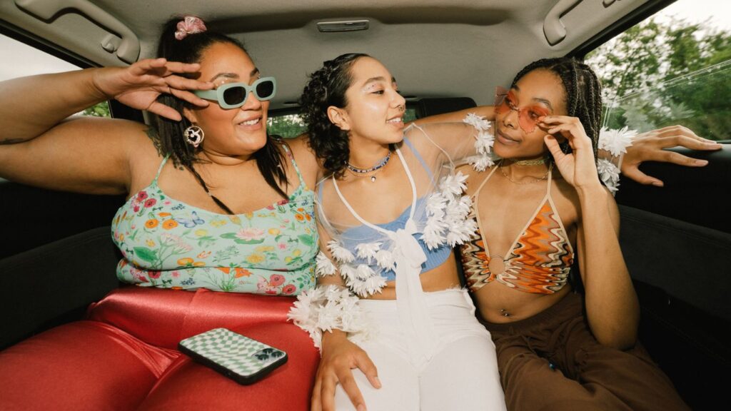 three girls having fun in a luxury car by la confidential
